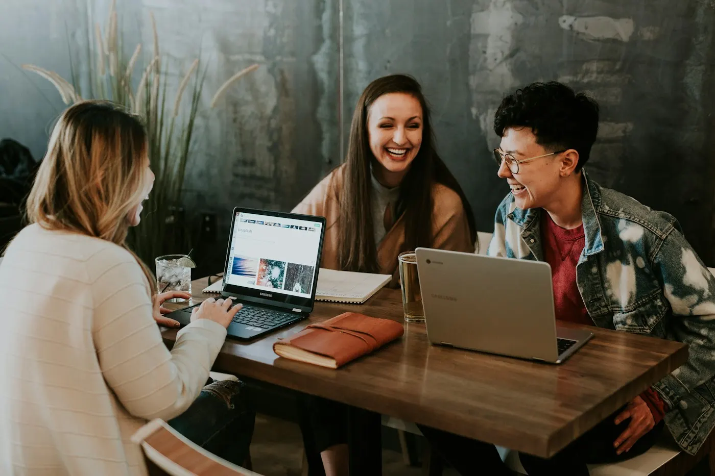 Three students studying together around laptops