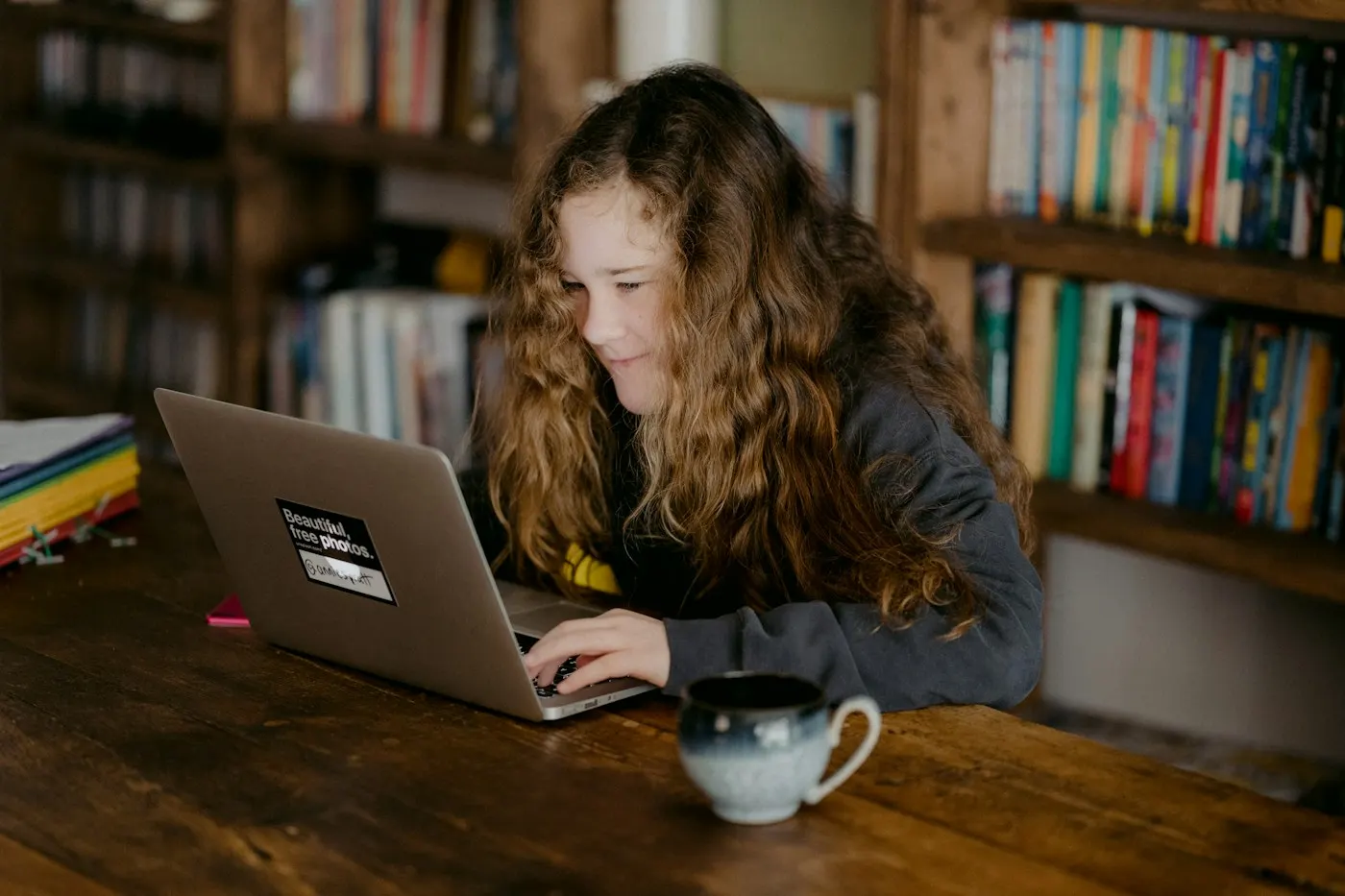 A student working on a laptop with a cup of coffee